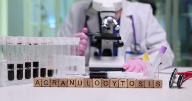 Mikroskop ve çeşitli kan örnekleri titizlikle laboratuvar ortamında agranulolitozu incelemeye odaklanıyor.