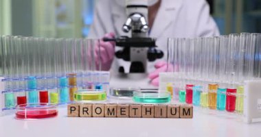 Prometyum renkli test tüpleri ve bilimsel araştırmalar için mikroskop içeren bir laboratuvar düzeneği..