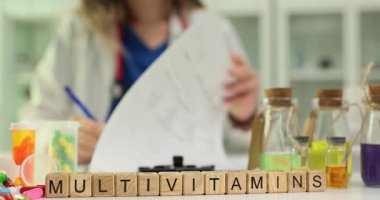 Kadın doktor, hastanın sağlığını desteklemek için Multivitaminler için reçete yazıyor. Doktor hastaya günlük multivitamin kullanımının faydalarını açıklıyor
