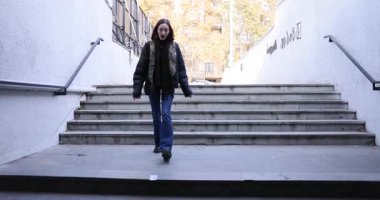 Genç bir kadın, dolar banknotunun şehir altgeçidinde beton basamaklara indiğini gördü. Esmer kadın şehir sokağında beklenmedik para geliri karşısında şaşırdı.