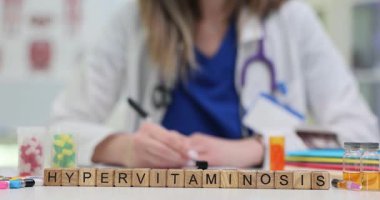 Tahta bloklara yazı yazan doktorlara karşı Hypervitaminosis yaz. Kadın doktor hastanede hasta bakımını ve sağlık yönetimini güvence altına alır