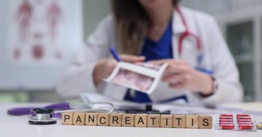 Kadın doktor, masada otururken pankreatit teşhisi için ultrason taraması yapıyor. Hastane ortamında pankreatitin tıbbi durumu