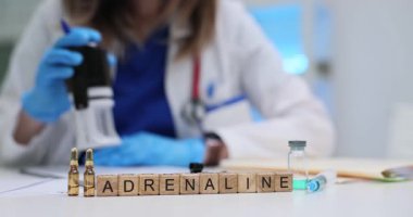 Kadın doktor, Adrenalin kelimesi, ampuller ve şırınga yakınlarındaki belgeleri masasına yapıştırıyor. Klinikte kritik acil bakım ve hormon tedavi protokolleri