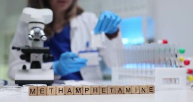Tıp laboratuarındaki tahta küplere metamfetamin yaz. Kadın bilim adamı, kriminal laboratuarında analiz için beyaz toz ilacı örneği hazırlıyor.