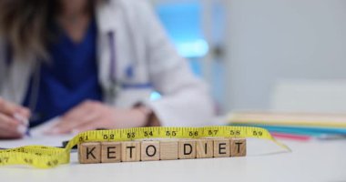 Keto Diyet 'i tahta bloklara mesaj at. Doktor masasında mezura olsun. Kadın beslenme uzmanı kilo yönetimi için sağlıklı beslenme alışkanlıkları tavsiye ediyor