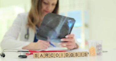 Tahta küplerde sarkoidoz ve klinikte göğüs röntgeni çeken bir doktor. Doktor akciğerlerdeki bağışıklık sistemi hücrelerinin küçük koleksiyonlarını kontrol ediyor.