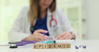 Klinikteki meşgul doktorun yanında şırıngayla ahşap tıkanıklıklarda salgın var. Kadın tıp uzmanı bulaşıcı hastalıkların yayılmasıyla ilgili rapor yazdı.