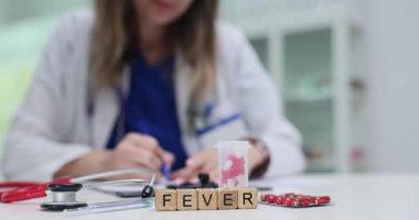 Tahta bloklarda steteskop ve hastanede doktorların yanında su toplayan haplarla ilgili haberler var. Kadın terapist klinikteki hastalara teşhis koydu