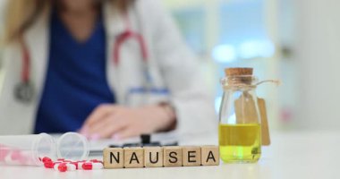 Ahşap blokların bulantısı ve masadaki doktorlara karşı ilaçlar. Kadın hekim hasta bakımına ve etkili tedavi seçeneklerine odaklanıyor