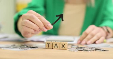 Muhasebeci vergileri vergi ve yükselen okla işaretlenmiş tahta küplerle arttırıyor. Vergi oranları ve mali yükümlülüklerdeki önemli artışın sembolü