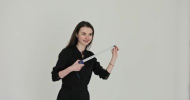 Genç mimar, beyaz arka planda mezuraları kontrol ediyor. Mutlu kadın, ağır çekimde profesyonel hassasiyet gösteriyor.