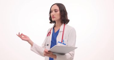 Beyaz önlüklü genç bayan doktor ve steteskop elinde işaret parmağıyla pano tutuyor. Beyaz arkaplan yakınlarındaki bir hastaya danışma