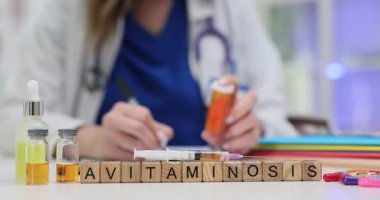 Doktor masadaki şırınga hapları ve ampullerin yanında Avitaminosis tedavisi için reçete yazıyor. Vitamin eksikliği teşhisine odaklan. Ağır çekim.