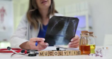 Kadın tıbbi uzman, akciğer röntgenini inceledi. Mucolytic ilaç yazıyormuş. Teşhis süreci ve hasta tedavi stratejisine odaklanma