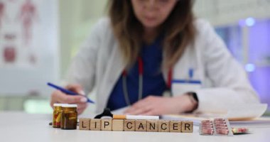 Doktor, Lip Cancer tedavisi için masada sigara ve haplarla reçete yazıyor. Sigara içmenin tehlikeleri ve tıbbi bakımın önemi