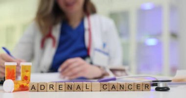 Kadın doktor masasında haplarla Adrenal Kanser tedavisi için reçete yazıyor. Klinikte hasta bakımı ve terapinin önemi