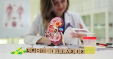 Klinikte idrar örneği ve böbrek örneğiyle birlikte tahta küplere Urolithiasis yaz. Kadın terapist hastanedeki hastanın ultrason taramalarını inceliyor.