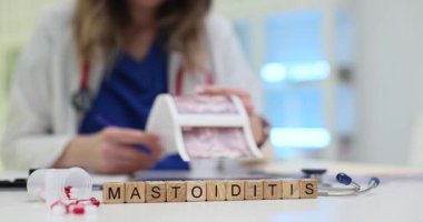 Tahta küplere Mastoiditis 'i ve klinikte röntgen görüntülerini inceleyen doktoru yaz. Kadın doktor kulak hastalığı teşhisi ve tedavisine odaklanıyor