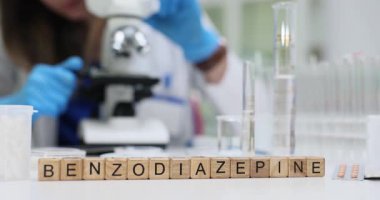 Kadın bilim adamı, modern laboratuarlardaki küpler üzerinde gösterilen Benzodiazepin 'i özenle analiz ediyor. Tıp ve araştırma alanında gelişmeler