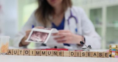 Kadın doktor, tıp bürosunda otoimmün hastalıkları analiz eden belgelerle çalışıyor. Otoimmün hastalıkların nedenleri ve tedavisi araştırılıyor.