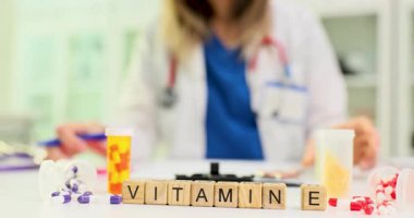 Doktora karşı renk kapsülleri arasında tahta küplere E vitamini uygula. Kadın terapist, ağır çekimde sağlık ve sağlığa önem veriyor.