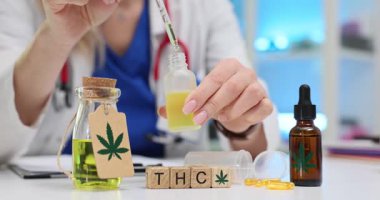 Tahta bloklara THC harfleri ve klinikte tıbbi kenevir yağı damlatan bir doktor. Kadın doktor hastanede alternatif ilaç tedavisi öneriyor.