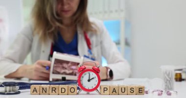 Tahta blokların alarm saati ve ultrason taraması olan doktorların Andropause 'u. Kadın doktor, erkek hormonu seviyesini kontrol ediyor.