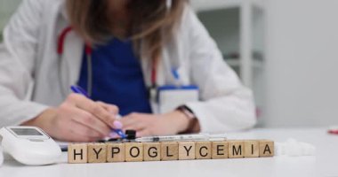 Tahta küplerin hipoglisemisi ve klinikte yazan kadın doktor. Glukometre insülin şırıngası ve şeker küplü doktor randevuda.