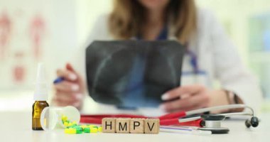 Doktor, ahşap küplerle yazılmış HMPV teşhisini analiz eden akciğer röntgeni resmi tutuyor. İnsan metafnömotorirüsü ve solunum sistemine etkileri