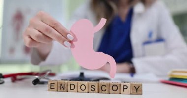 Kadın tıbbi uzman, hastayla Endoskopi prosedürünü tartışırken mide anatomik modelini gösteriyor. Sindirim sistemi danışmanlığı