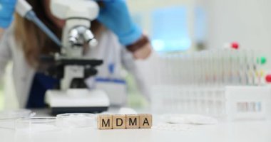Bilim adamı mikroskop ve test tüpleriyle modern laboratuvarda MDMA ilacını analiz ediyor. Steril laboratuvar ortamında ilaç araştırmaları