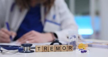 Kadın doktor, kağıt üzerinde Tremor teşhisi, ilaç ve steteskop ile yazar. Modern klinikte ilaç tedavisi için reçete