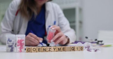 Doktor kapsül tutarken Coenzim Q10 için reçete yazıyor. Hasta bakımı ve tedavisinde beslenme ve sağlığın önemi