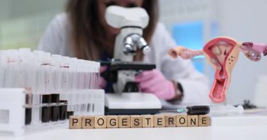 Bilim adamı mikroskop kullanarak kan örneklerini analiz ediyor ve Progesteron hormonu üzerinde çalışıyor. Doğurganlık ve tedavi araştırmaları için kadın üreme sistemi