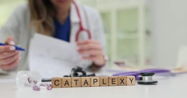 Tıp doktoru hasta belgelerini katapleksi teşhisi ile analiz ediyor. Hastanedeki masada ilaç ve steteskopla tedavi seçenekleri