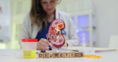 Doktor diüretikler için reçete yazıyor klinikte anatomik böbrek ve idrar örneği gösteriyor. Kadın, sağlık ve tedaviyi vurguluyor