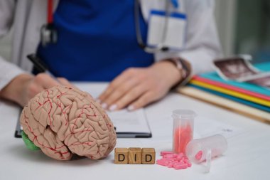 Bir tıp uzmanı bir beyin modelini inceler, zihinsel sağlık temaları ve psikolojik çalışmalar vurgulanır.