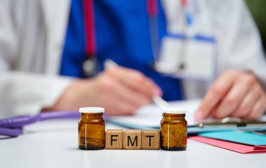 Bir sağlık uzmanı düşünceli bir şekilde dışkı mikro-biota nakli FMT prosedürlerini gerçekleştirmeye hazırlanıyor.