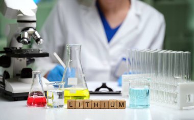 Yetenekli bir bilim adamı laboratuvarda lityum analiz eder, cam eşyalar ve hassas ölçümler için aletler sergiler.