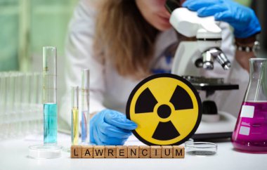 Mikroskobik slaytları derinlemesine inceleyen bir bilim adamı lawrensiyum elementini mikroskop altında gösterir.