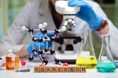 Bir bilim adamı Oganesson ile ilgili moleküler yapıları ve bileşikleri bir laboratuvar ortamında inceliyor..