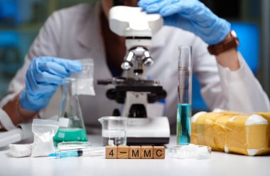 Laboratuvar ortamında, bir araştırmacı mikroskop kullanarak çeşitli örnekleri dikkatle inceler.
