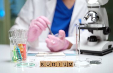 Bir bilim adamı, özel ekipman ve hassas mikroskop kullanarak laboratuvarda sodyum örneklerini analiz eder.
