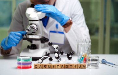 Çağdaş bir laboratuvar ortamında, kendini adamış bir araştırmacı mikroskop kullanarak örnekleri dikkatle inceliyor.