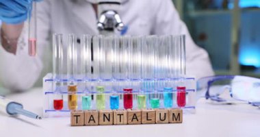 Yetenekli bir bilim adamı, tantalum üzerinde çalışırken renkli sıvıları içeren bir deneyi titizlikle yürütüyor.