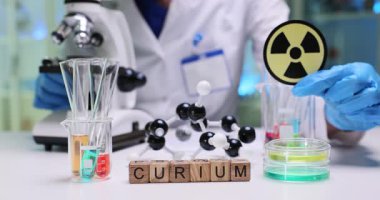 Curium, moleküler modeller ve radyoaktivite odaklı araştırma ekipmanlarını gösteren bir laboratuvar sahnesi..