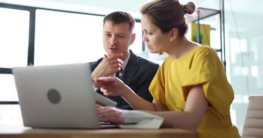 İş adamları verileri analiz etmek için dizüstü bilgisayarla proje üzerinde işbirliği yapıyor. Parlak modern ofis ortamında toplantı sırasında aktif tartışma