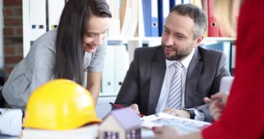 Mimari profesyoneller tasarım geliştirme sırasında sabit şapka yakınındaki proje paylaşımı kavrayışlarını tartışıyor. İnşaat projesinde ortaklaşa planlama