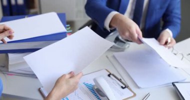 İş ortakları modern ofiste toplantı sırasında belgeleri zımbalayıp yumrukluyor. Çalışma odasındaki evrak işlerinde çalışırken işbirliğini kapat