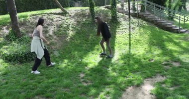 Aktif kız arkadaşlar şehir parkında badminton oynamayı öğrenmeye çalışıyorlar. Yeni başlayanlar, mekiklere raketle vurarak sıcak bir atmosfer yaratıyorlar.